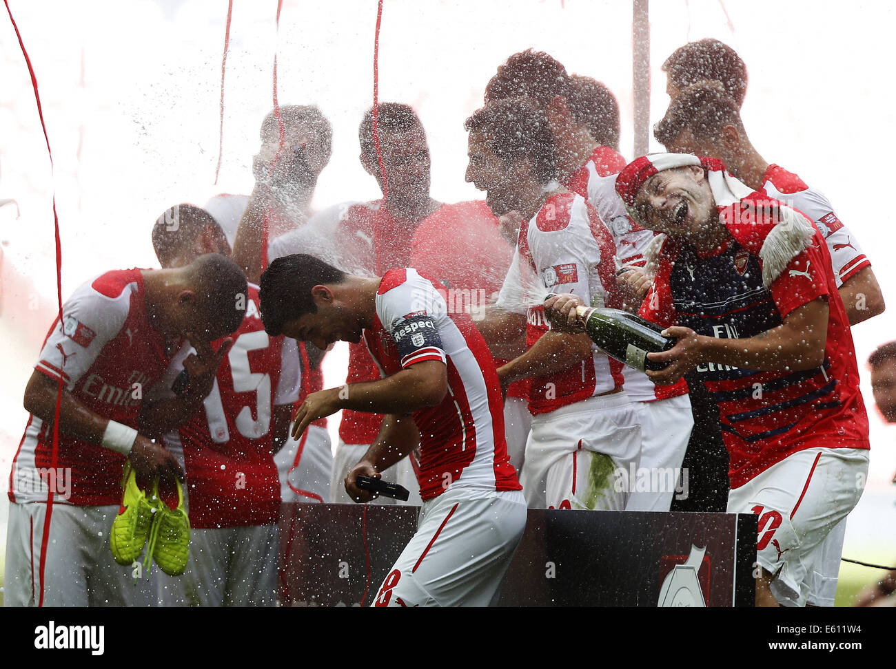 London, R) of Arsenal celebrates by spraying champagne towards his teammates after the Community Shield match between Arsenal and Manchester City at Wembley Stadium in London. 10th Aug, 2014. Jack Wilshere(1st, R) of Arsenal celebrates by spraying champagne towards his teammates after the Community Shield match between Arsenal and Manchester City at Wembley Stadium in London, Britain on Aug. 10, 2014. Arsenal won 3-0. Credit:  Wang Lili/Xinhua/Alamy Live News Stock Photo