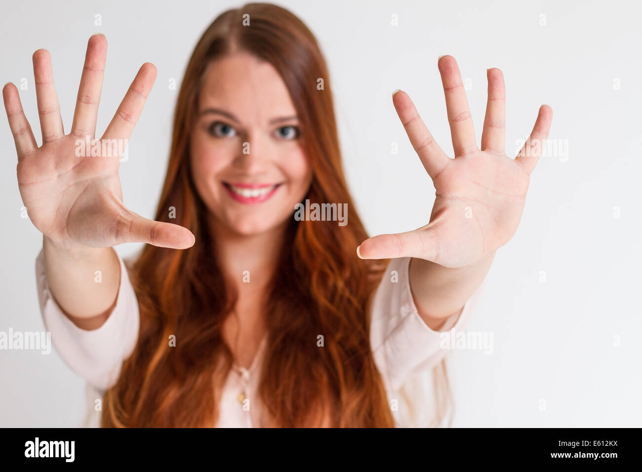 Redhead girl asking to stop with hands in a white isolated background Stock Photo