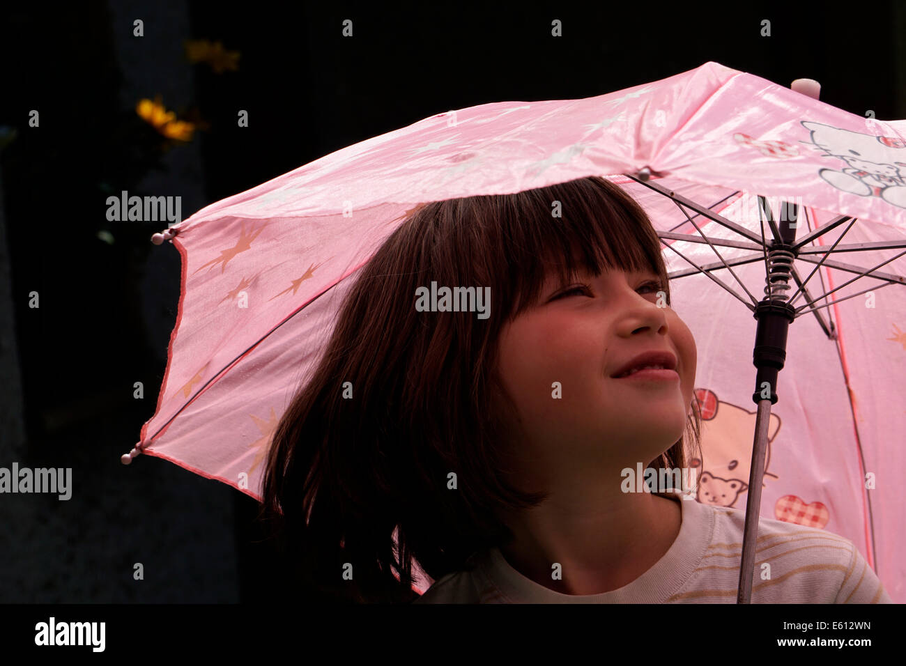 Young girl under pink umbrella Stock Photo