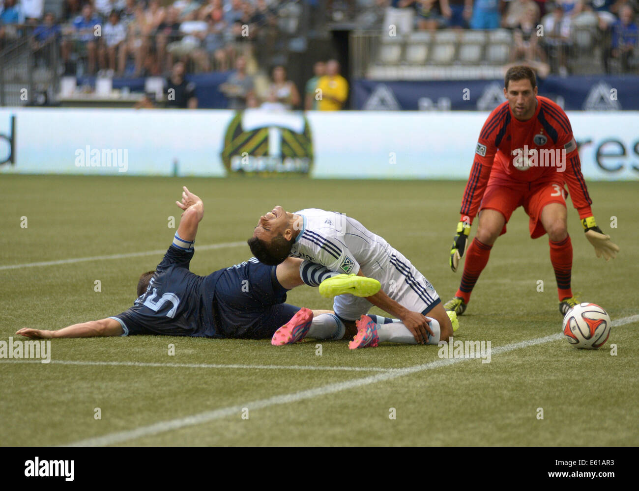 Vancouver, Canada. 10th Aug, 2014. Sporting Kansas City's Matt Besler (L) defends Vancouver Whitecaps' Sebastian Fernandez (C) from scoring a goal during their MLS soccer game at BC Place in Vancouver, Canada, on Aug. 10, 2014. Vancouver Whitecaps defeated Sporting KC by 2-0. © Sergei Bachlakov/Xinhua/Alamy Live News Stock Photo