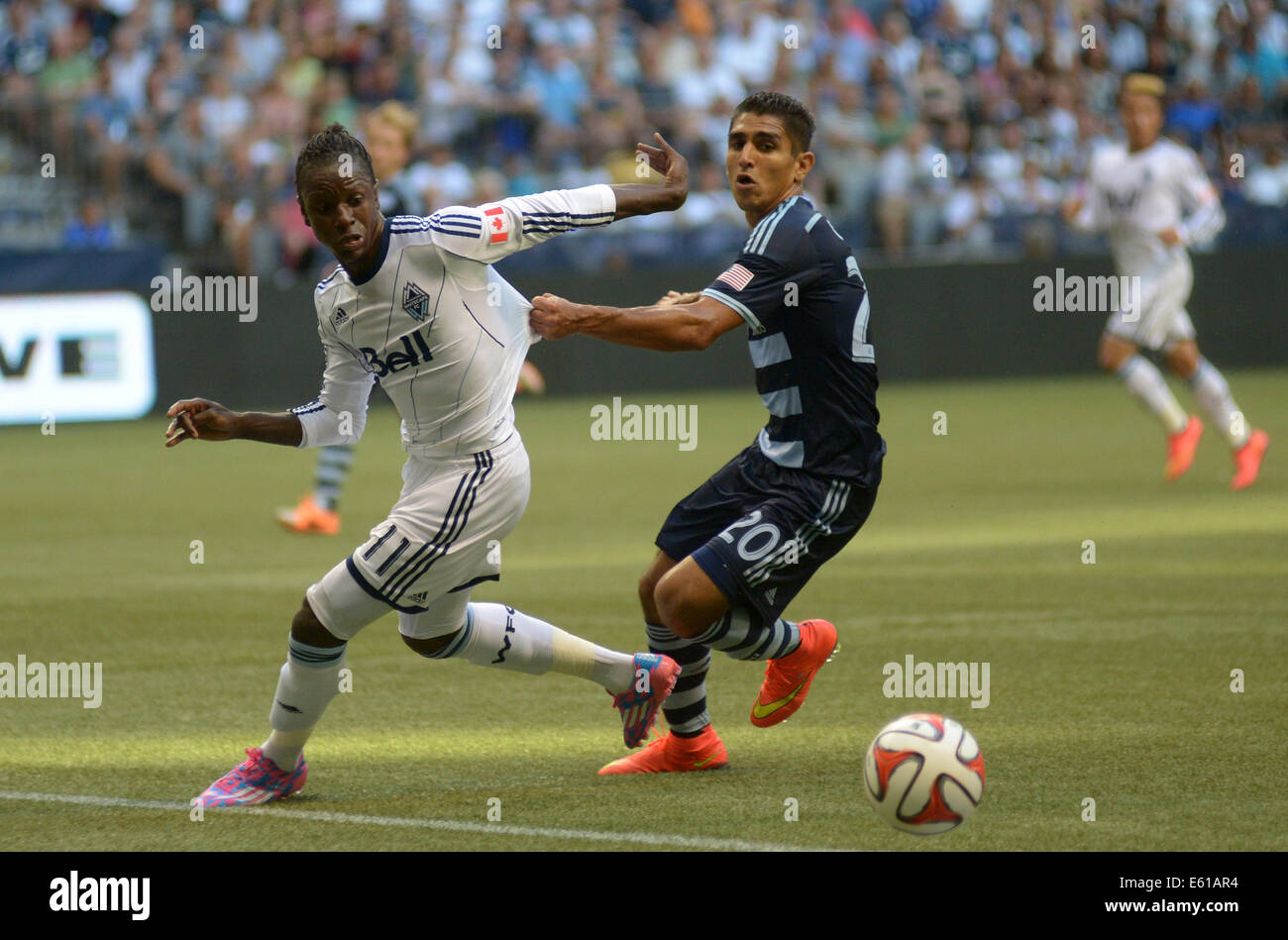 Vancouver, Canada. 10th Aug, 2014. Sporting Kansas City's Jorge Claros (R) vies with Vancouver Whitecaps' Darren Mattocks during their MLS soccer game at BC Place in Vancouver, Canada, on Aug. 10, 2014. Vancouver Whitecaps defeated Sporting KC by 2-0. © Sergei Bachlakov/Xinhua/Alamy Live News Stock Photo