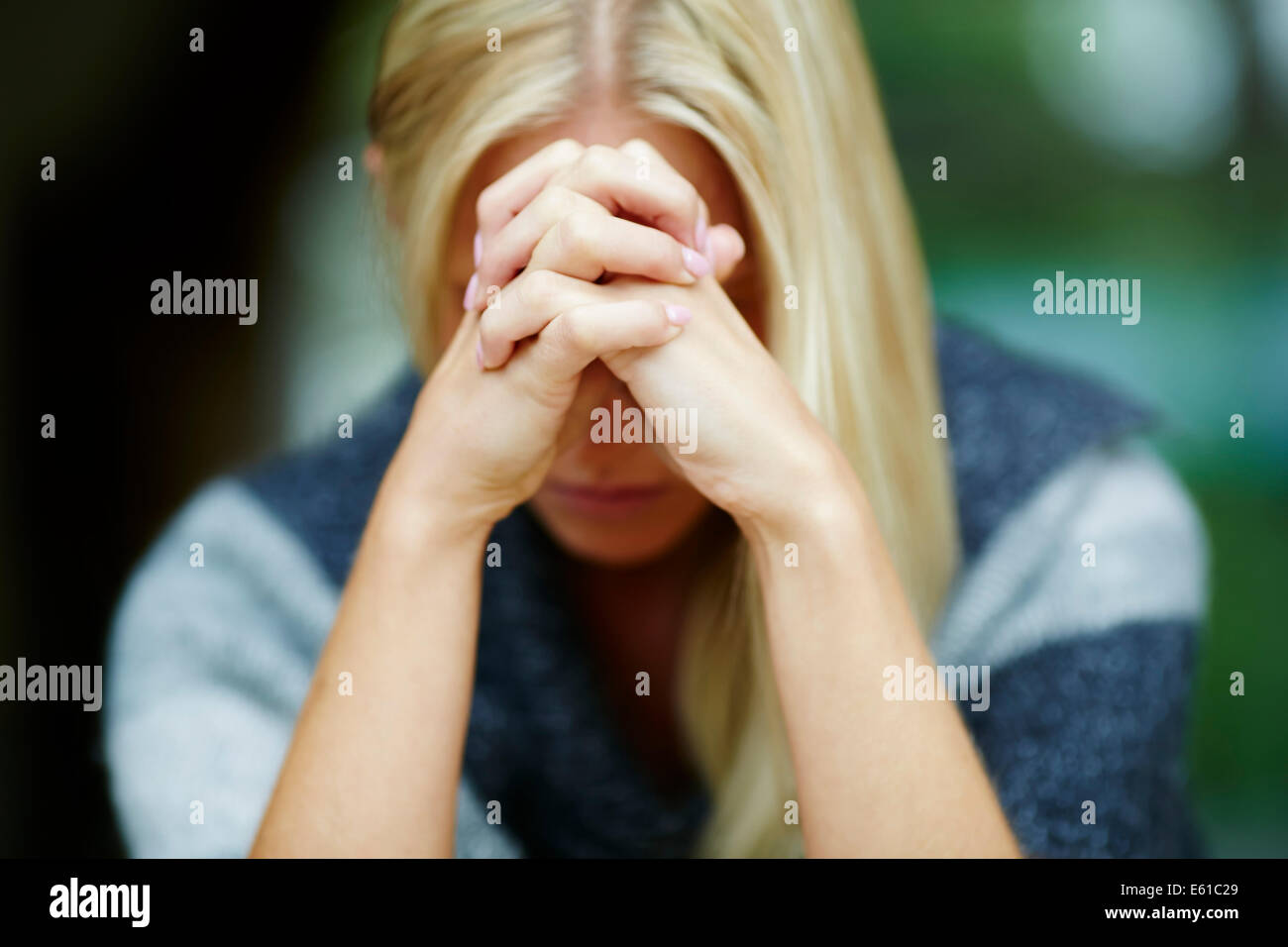 Woman with clasped hands Stock Photo