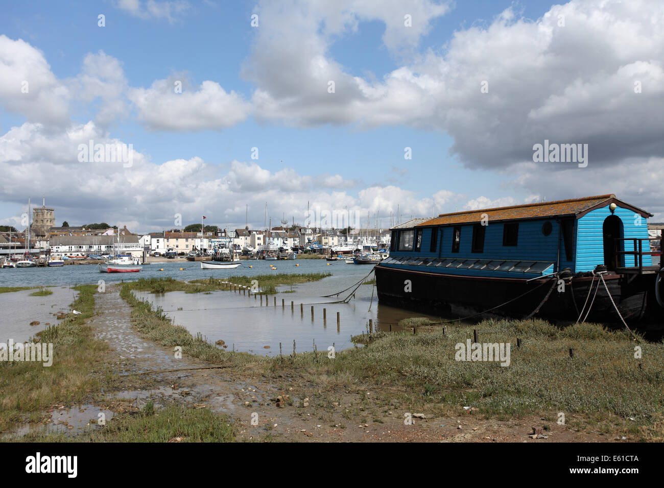 Houseboat moored on the river Adur with Shoreham-by-Sea in the background, Sussex Stock Photo