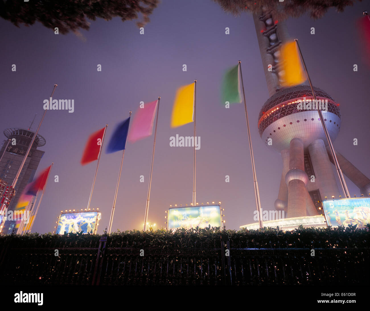 Illuminated Oriental Pearl TV Tower with colorful flags in front, Shanghai, China Stock Photo