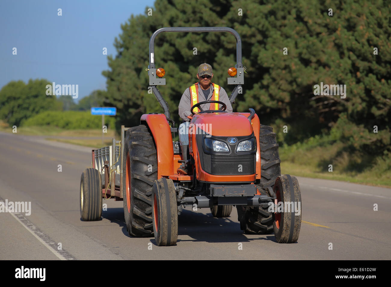 man driving farm transport vehicle road pavement Stock Photo