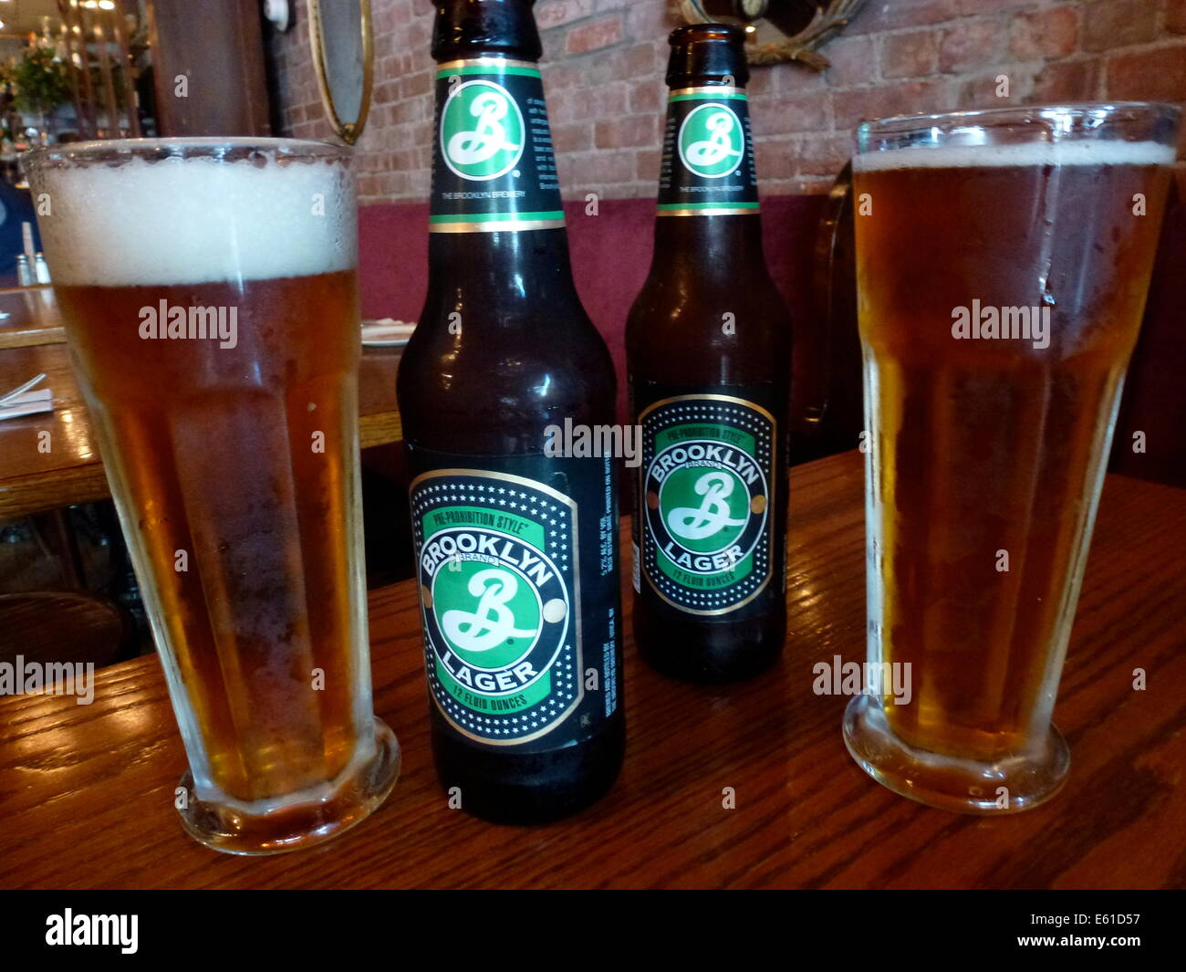 Two beer glasses and beer bottles with Brooklyn Lager Beer of the Brooklyn Brewery in New York, USA, 24 June 2014. The logo of the brewery was designed by Milton Glaser, who also designed the 'I love NY' logo. Photo: Alexandra Schuler/dpa - ATTENTION! NO WIRE SERVICE - Stock Photo