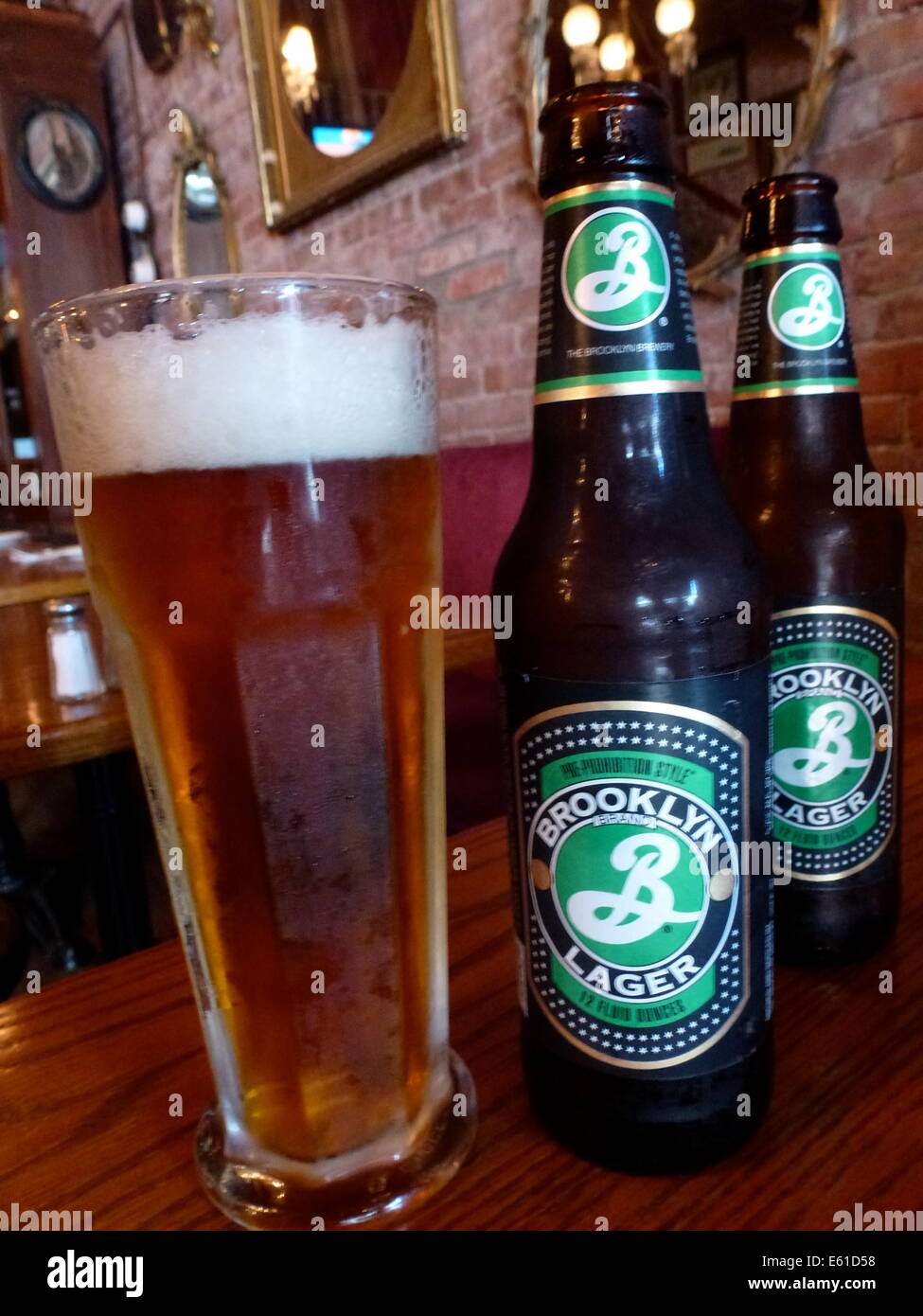A beer glass and beer bottles with Brooklyn Lager Beer of the Brooklyn Brewery in New York, USA, 24 June 2014. The logo of the brewery was designed by Milton Glaser, who also designed the 'I love NY' logo. Photo: Alexandra Schuler/dpa - ATTENTION! NO WIRE SERVICE - Stock Photo