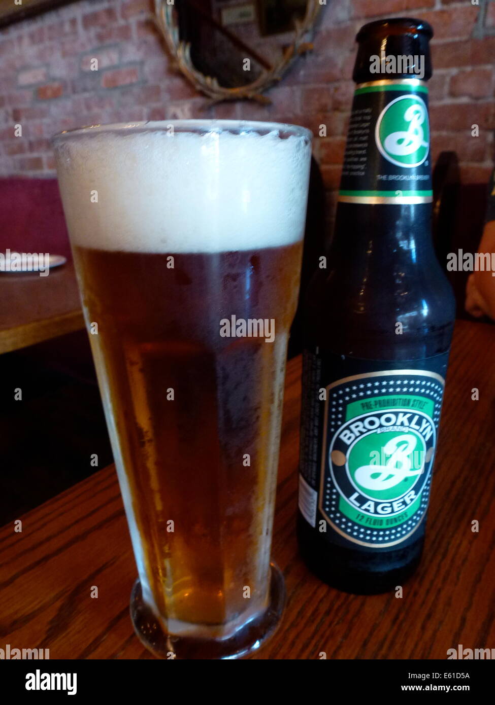 A beer glass and a beer bottle with Brooklyn Lager Beer of the Brooklyn Brewery in New York, USA, 24 June 2014. The logo of the brewery was designed by Milton Glaser, who also designed the 'I love NY' logo. Photo: Alexandra Schuler/dpa - ATTENTION! NO WIRE SERVICE - Stock Photo