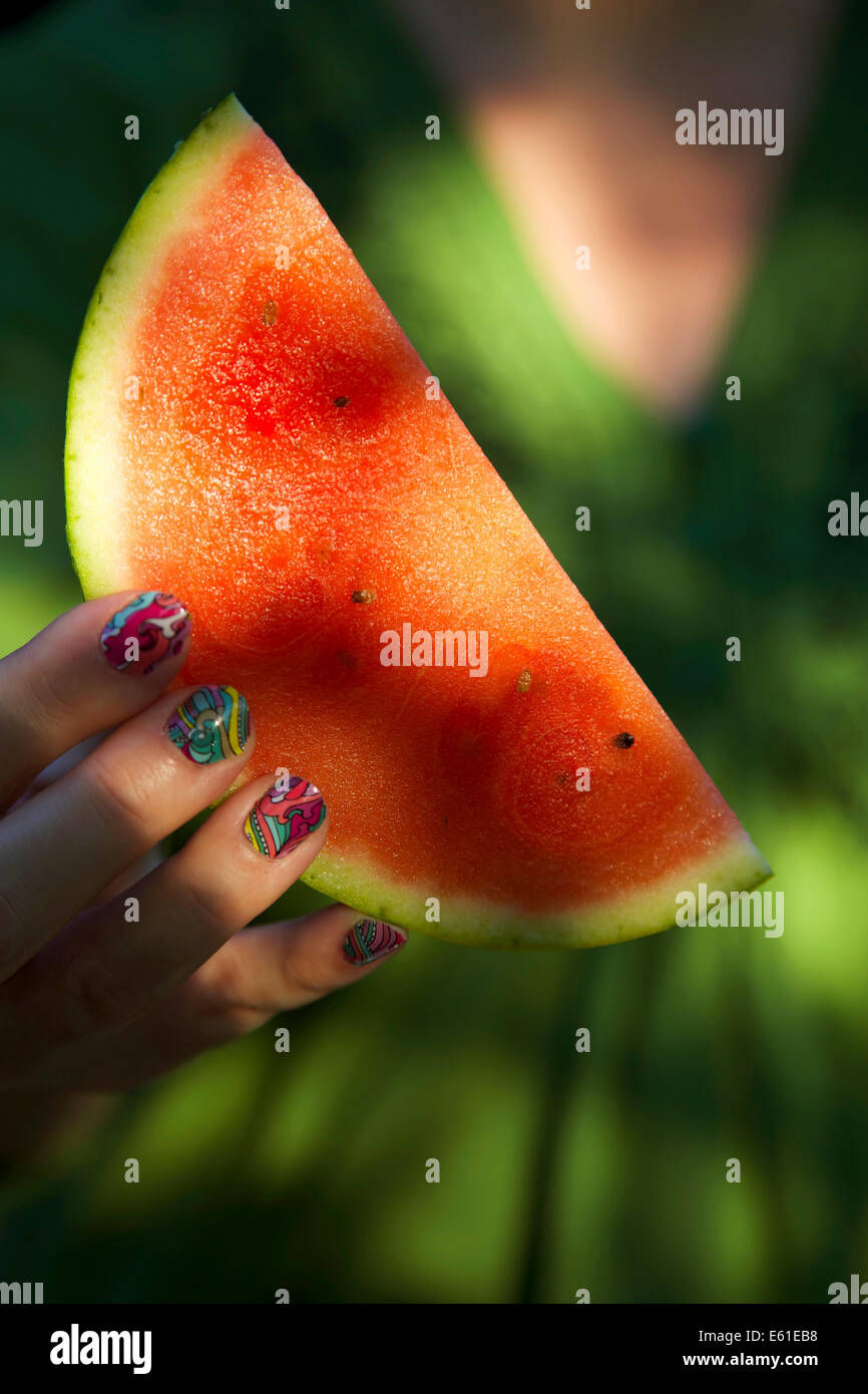 woman holding a fresh watermelon slice in her hands E61EB8