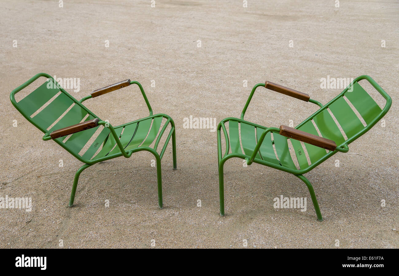 Two green chairs sit face to face in the Tuileries Garden Paris France. Stock Photo