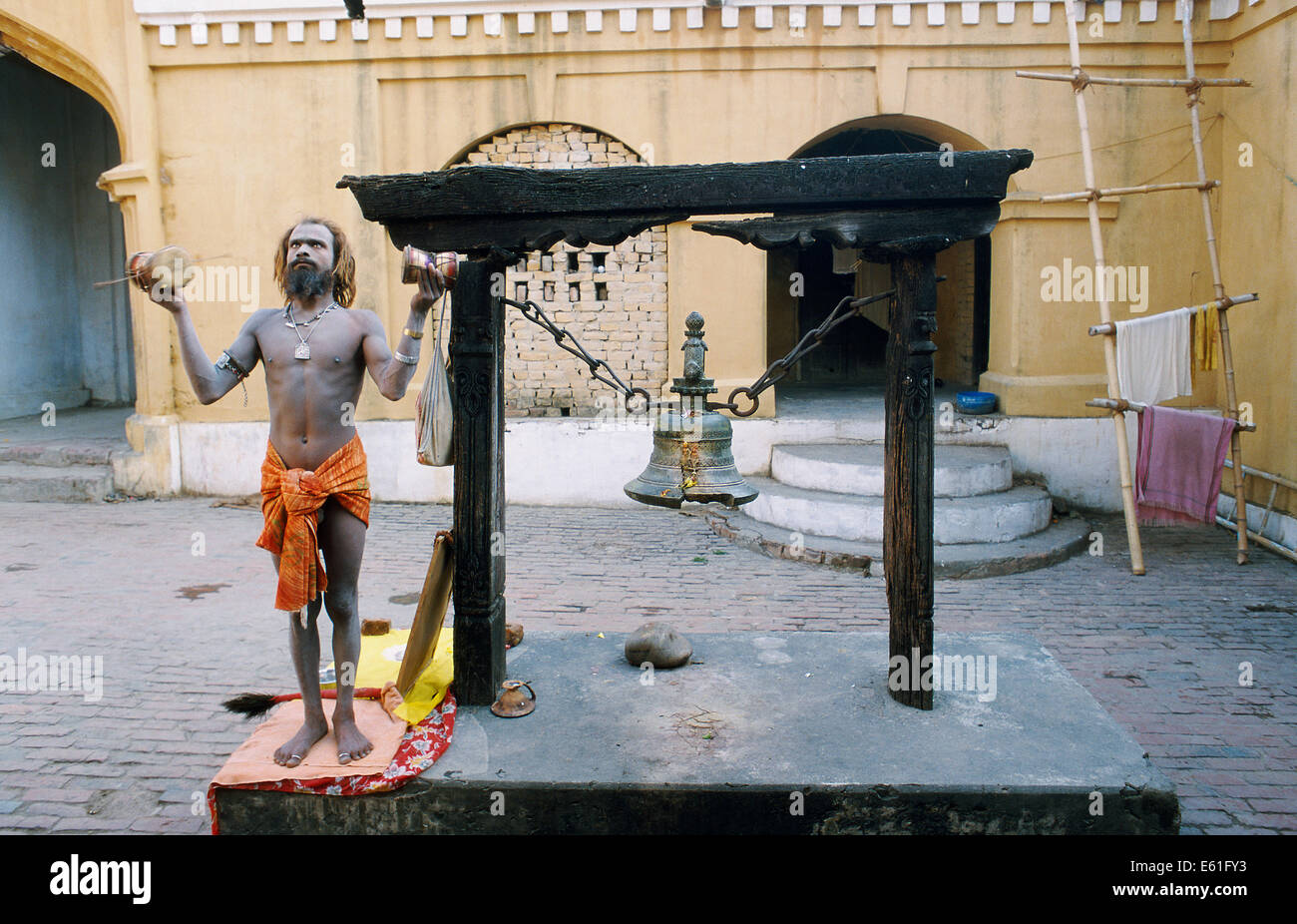 Hindu ascetic ('sadhu') worshiping the sun in a temple ( Nepal). He belongs to the Naga sect. Stock Photo