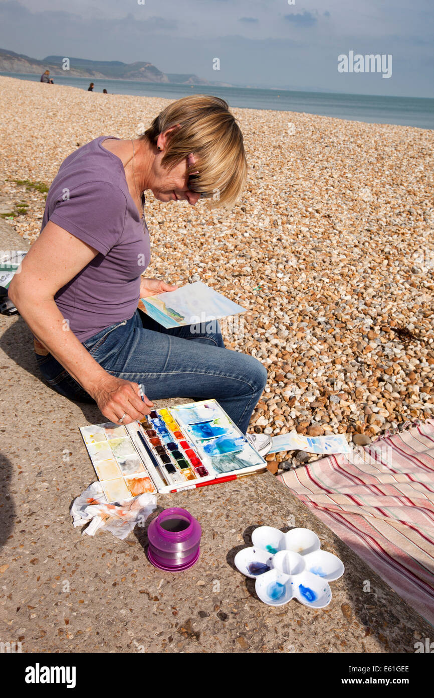 UK England, Dorset, Lyme Regis, amateur artist painting watercolour of Jurassic Coast Stock Photo
