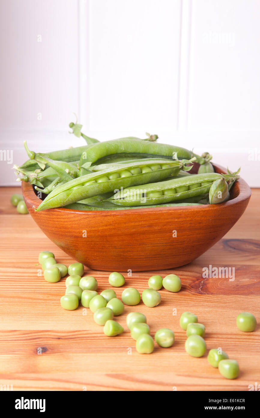 nice fresh peas in wooden bowl vertical picture Stock Photo