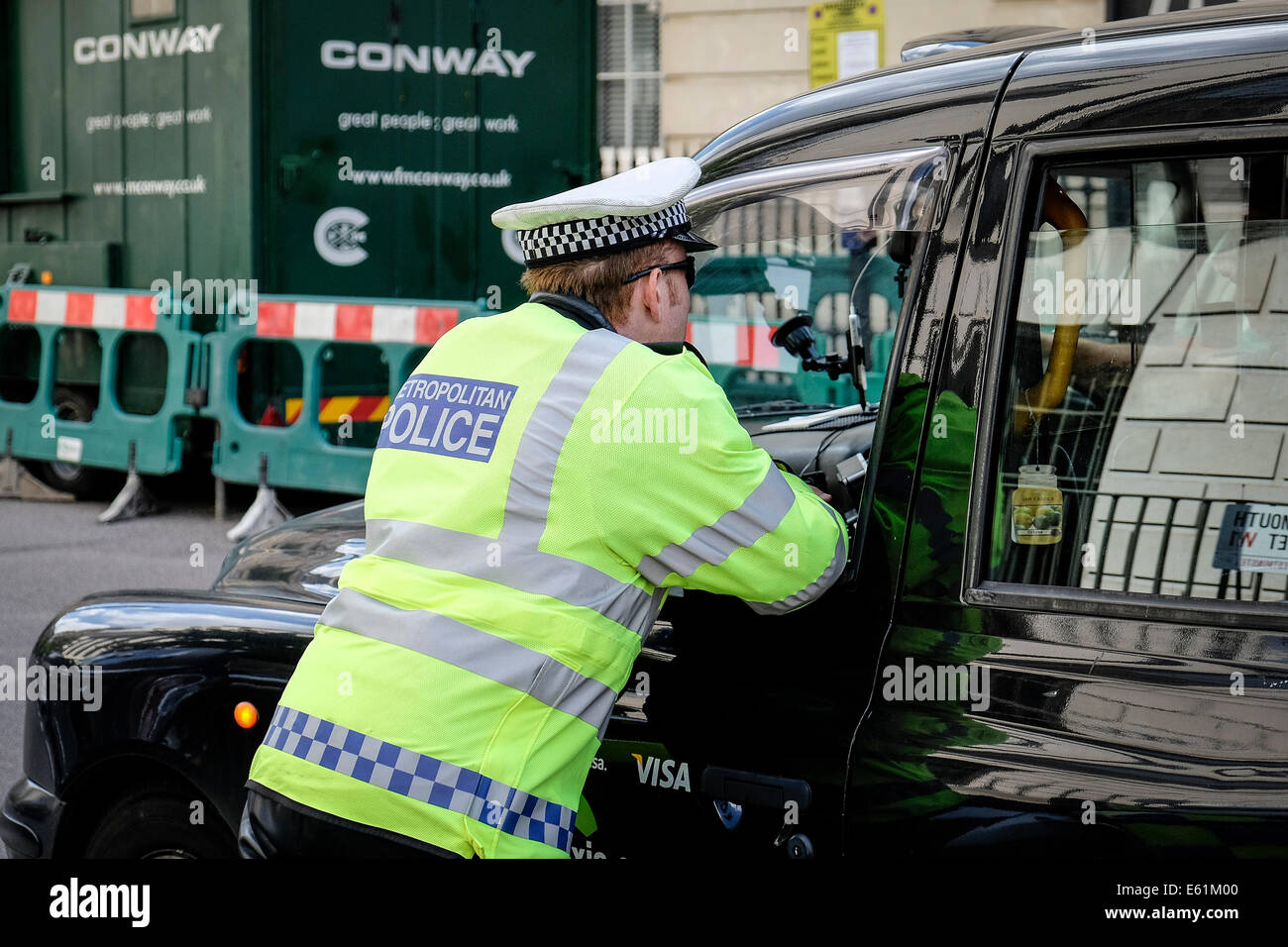 A Metropolitan police officer talking with a taxi driver. Stock Photo