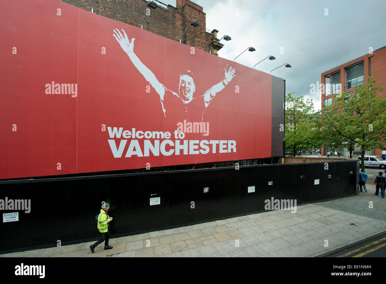 MANCHESTER, UK. 11th August, 2014. A billboard on Lever Street in the Piccadilly area of the city centre which parodies Manchester City's Carlos Tevez billboard in 2009 announces the start of Louis van Gaal's competitive tenure at Manchester United. The Dutchman is the 22nd manager of the club. Credit:  Russell Hart/Alamy Live News. Stock Photo