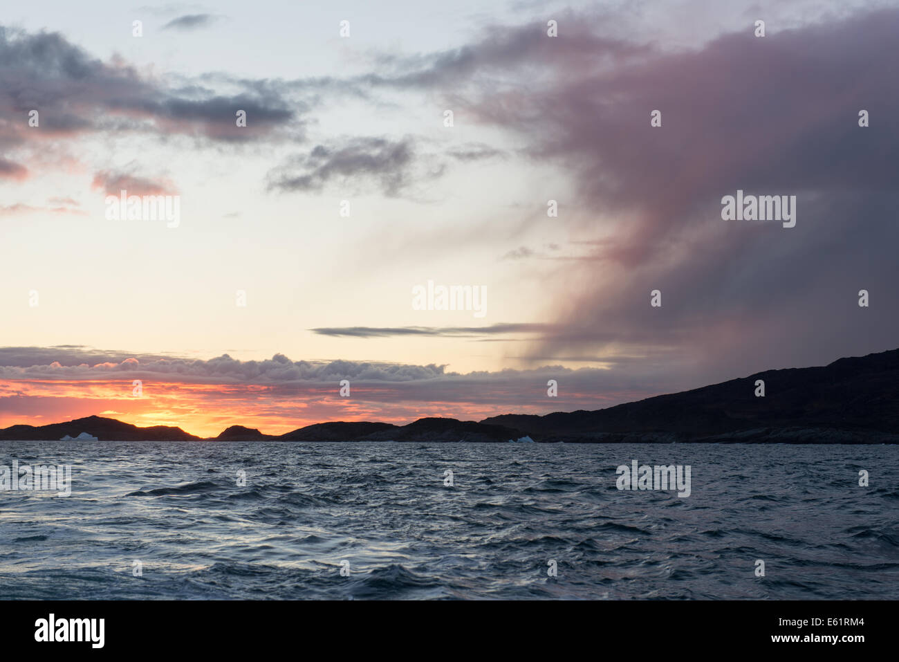 Sunset at arctic coast with cloudscape on Disko Island in Greenland Stock Photo