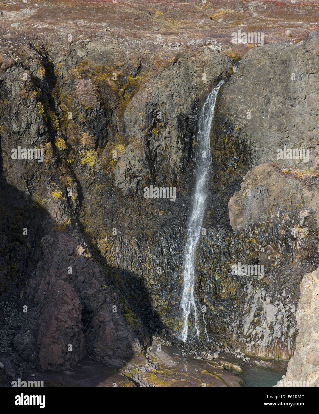 Closeup of a high waterfall in a rocky environment on Disko Island in Greenland Stock Photo