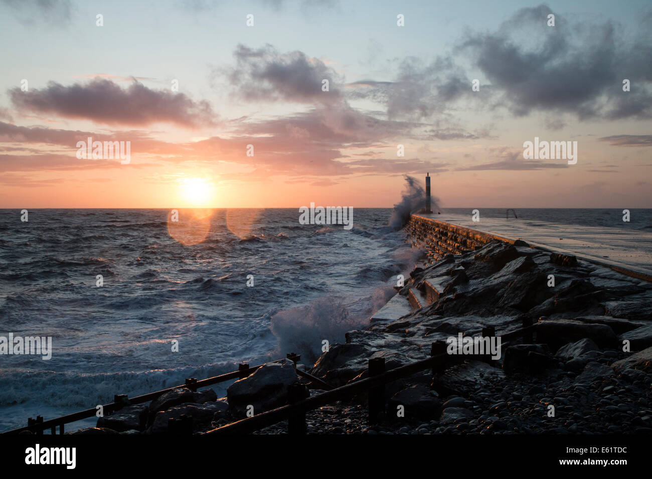 Aberystwyth, Wales, UK. 11th Aug, 2014. The sea whipped up by the storm called Bertha crashes waves against the Lighthouse in Aberystwyth at sunset. Credit:  Jon Freeman/Alamy Live News Stock Photo