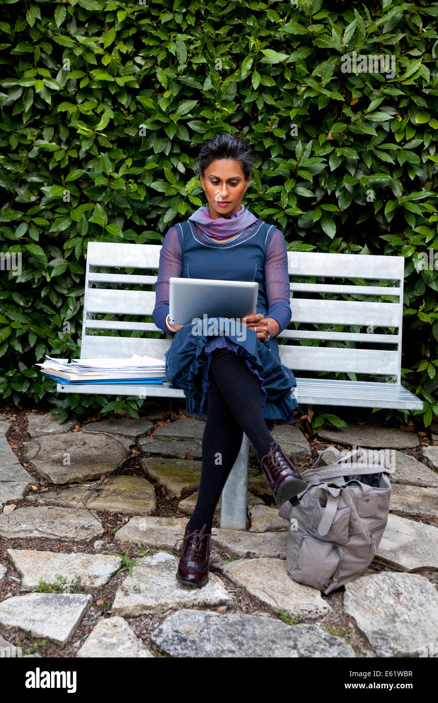 Businesswoman working on tablet outdoors Stock Photo