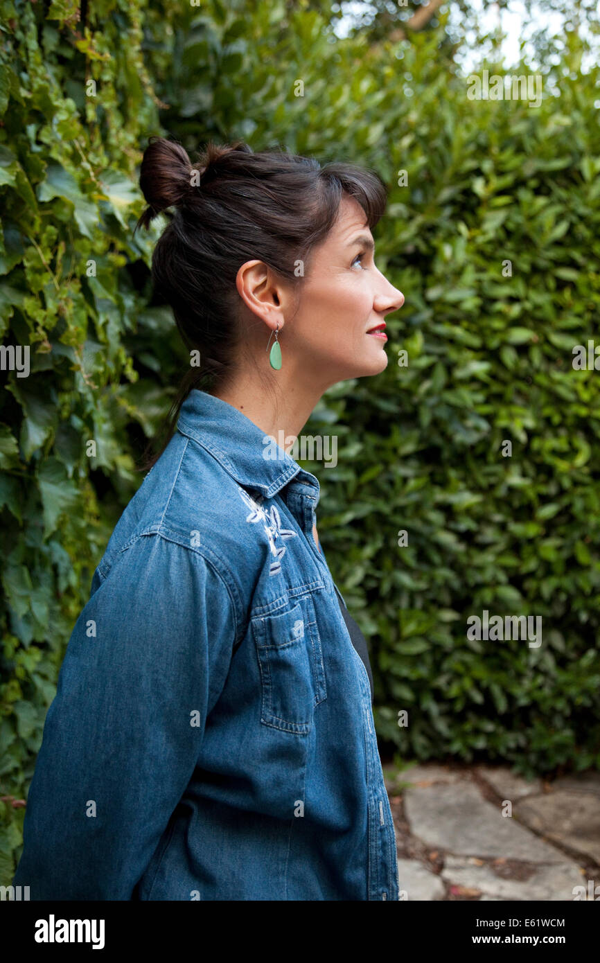 Profile of woman against hedge Stock Photo