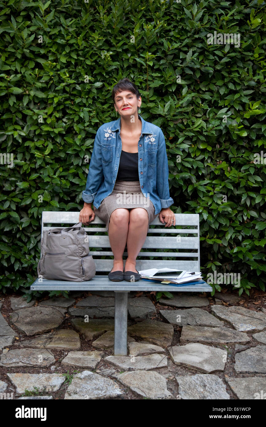 Woman sitting on bench top Stock Photo