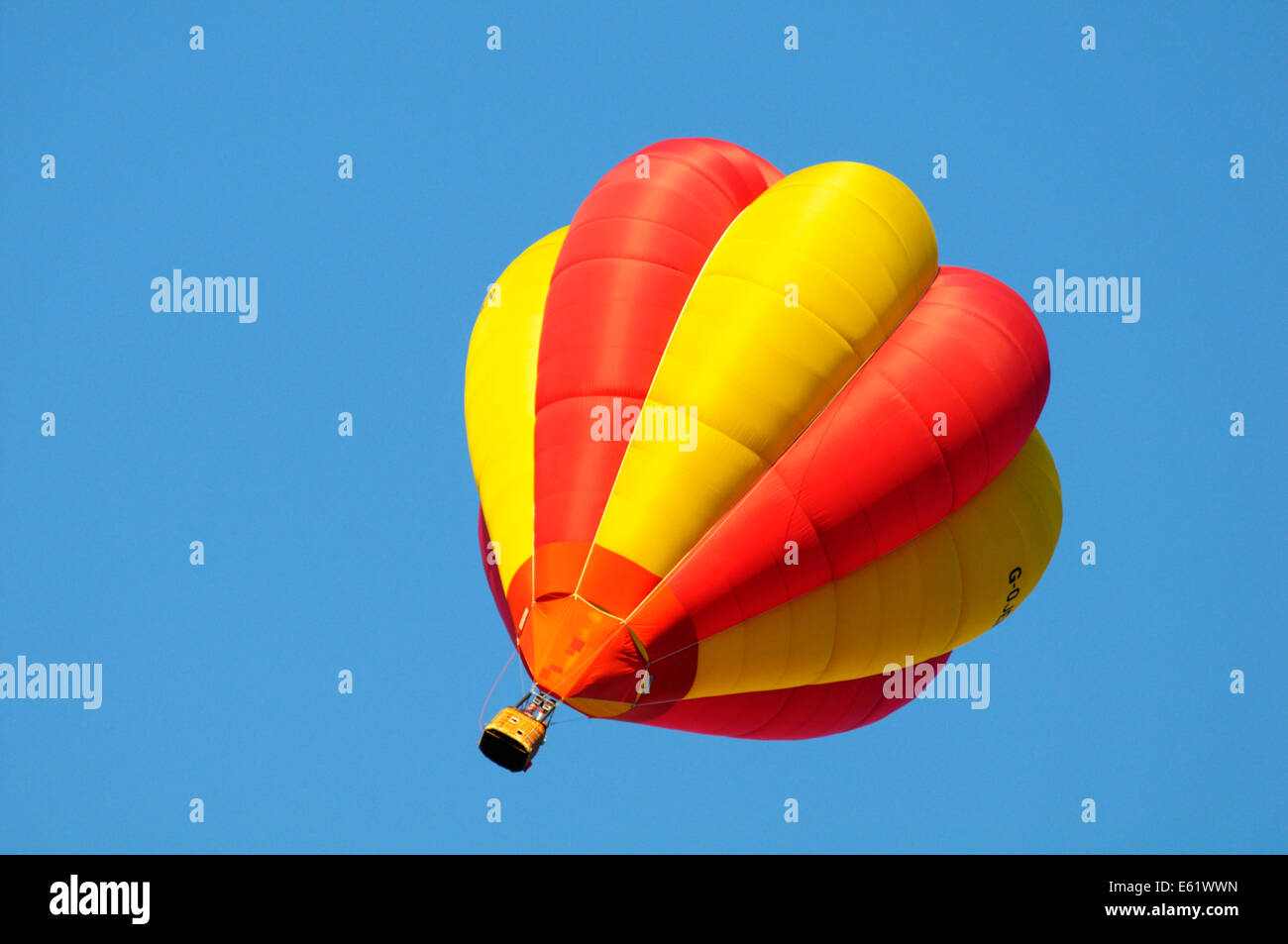 A colourful hot air balloon in flight with blue sky behind during the Bristol Balloon fiesta held annually Stock Photo