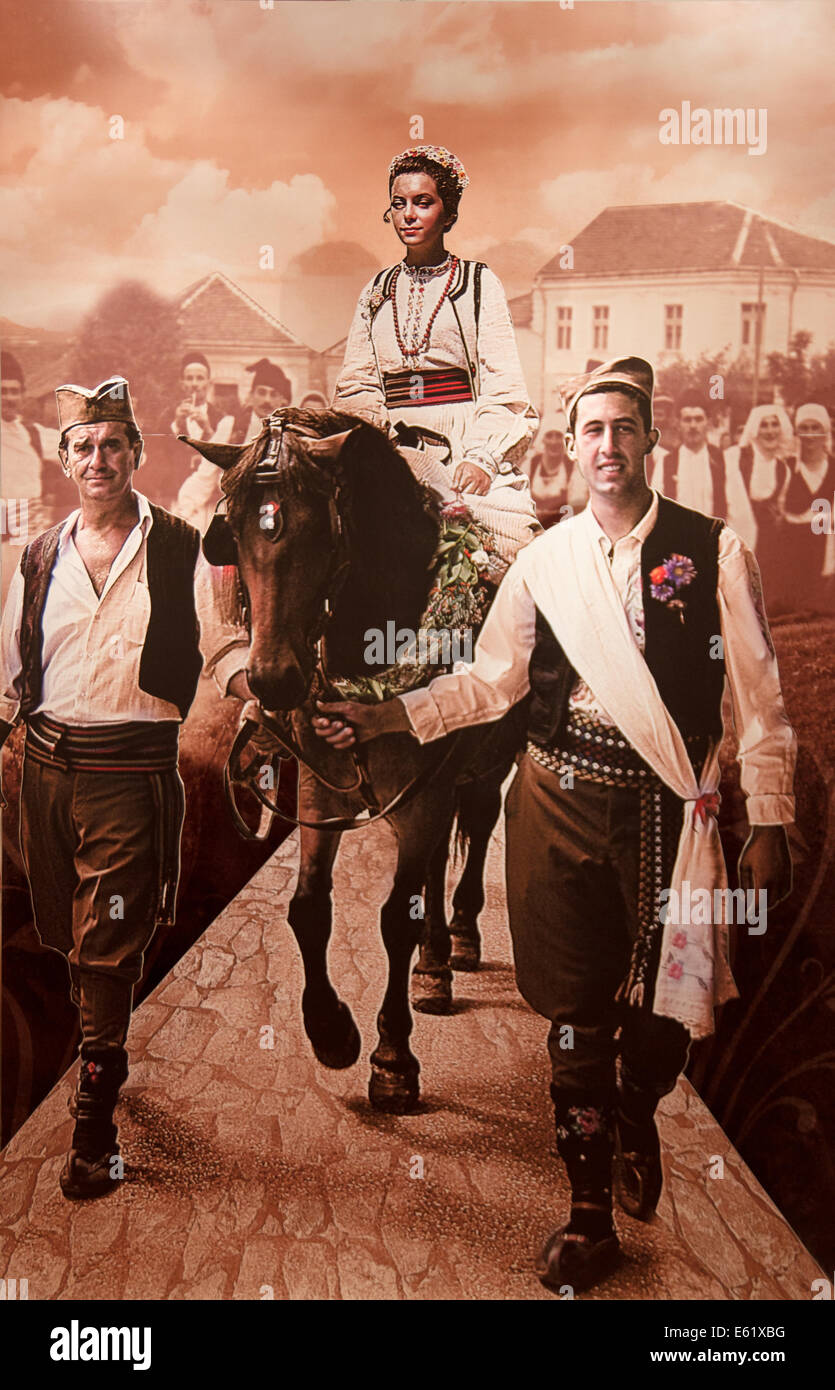 images from Serbian National Museum in Gucha Serbia 08.2014, married couple in traditional costume on road, vintage woman on hor Stock Photo