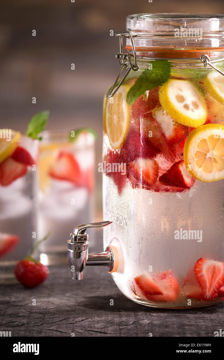 Large Mason Jar With Spout Filled With Infused Water Of Lemon Strawberries And Mint Two Glasses In Background Light Summery Stock Photo Alamy