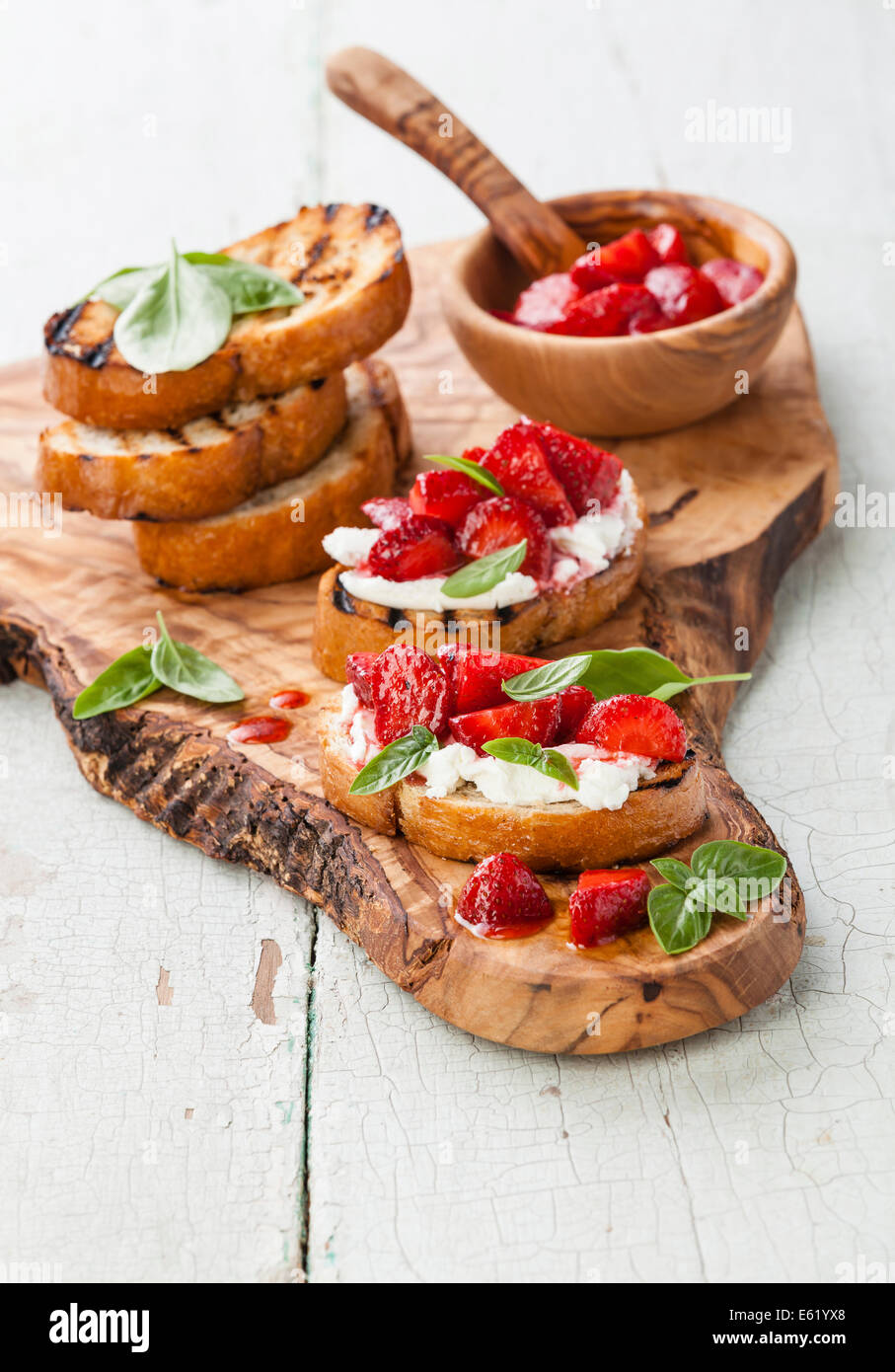 Italian bruschetta with chopped strawberry, basil and goat cheese on grilled crusty bread Stock Photo
