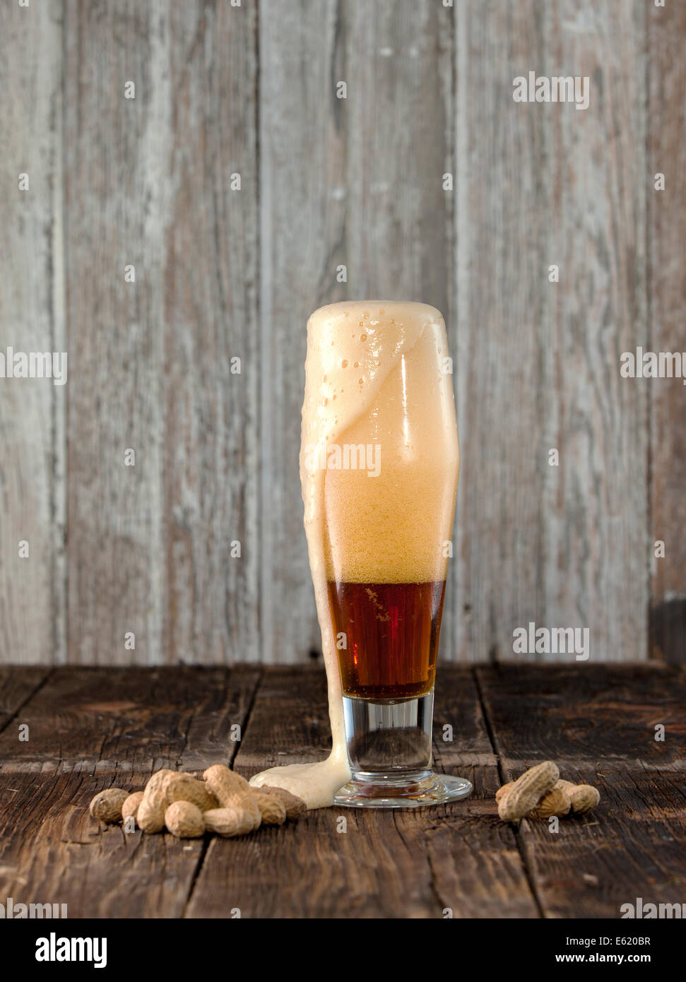 Frothy beer and peanuts. Stock Photo