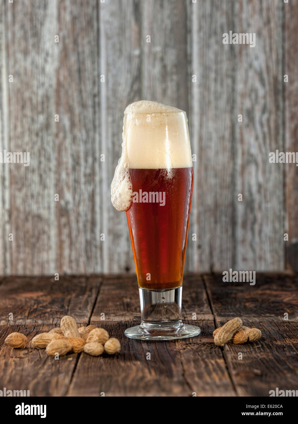 Peanuts and foaming beer. Stock Photo