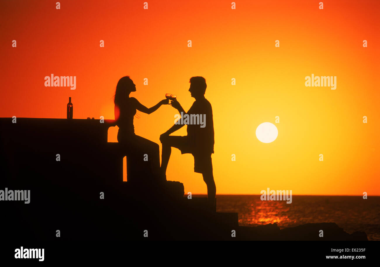 Couple toasting life and love at sunset Uruguay Stock Photo