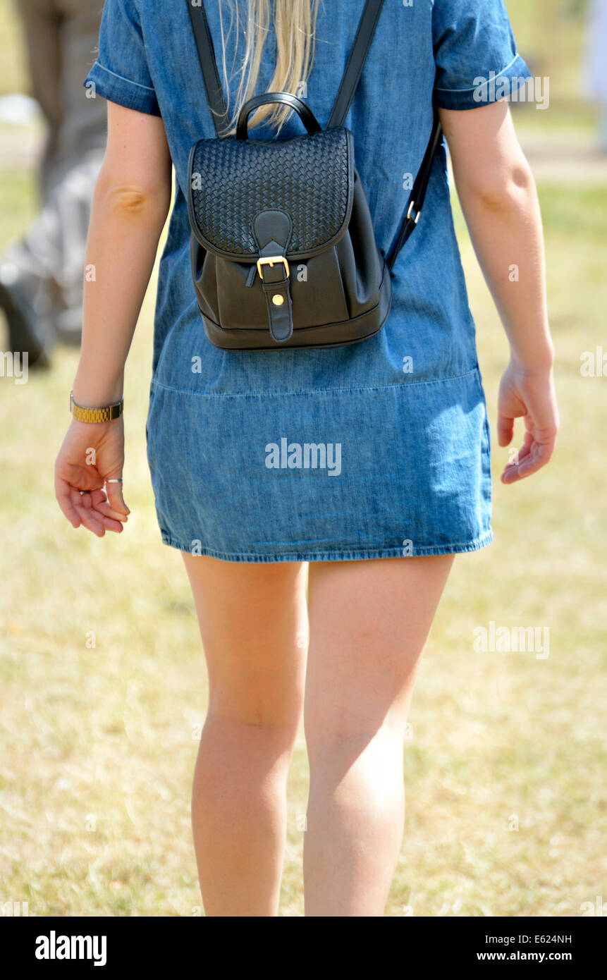 Young woman in a denim dress with a small backpack Stock Photo