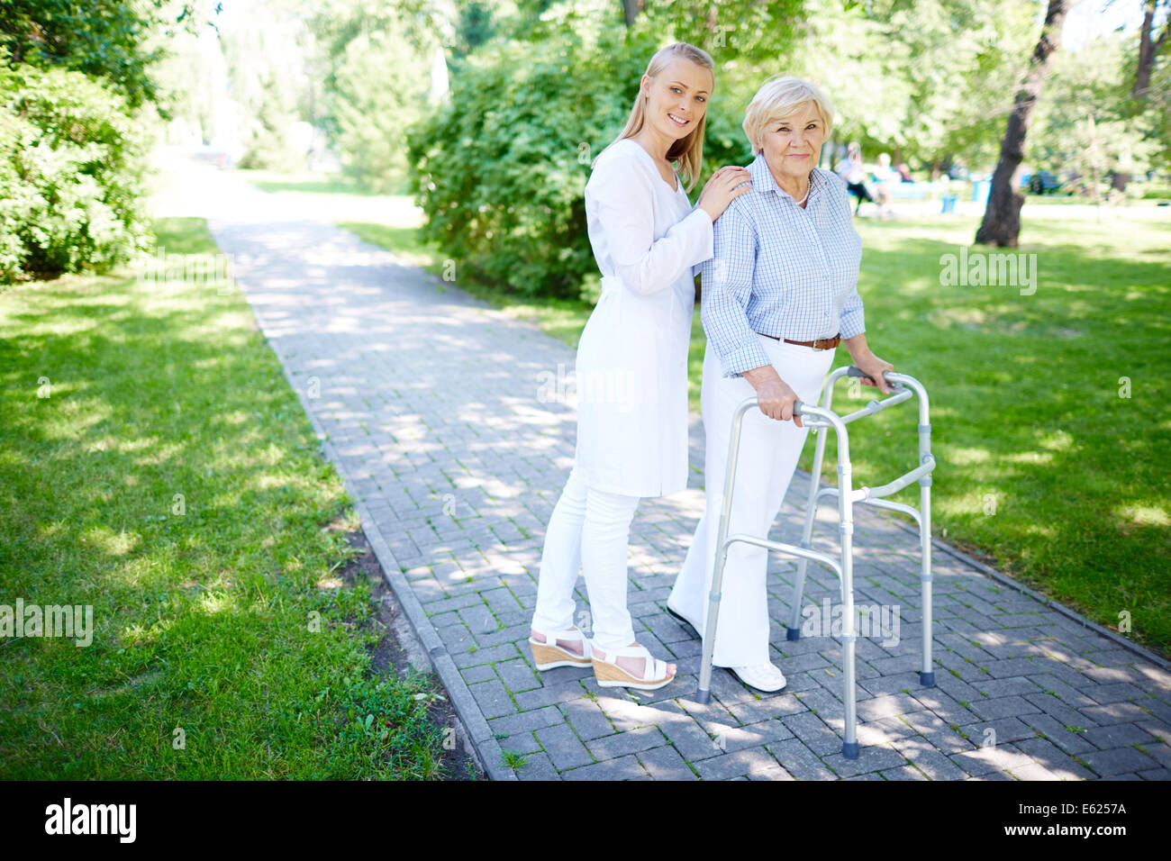 Pretty carer walking out with senior patient Stock Photo