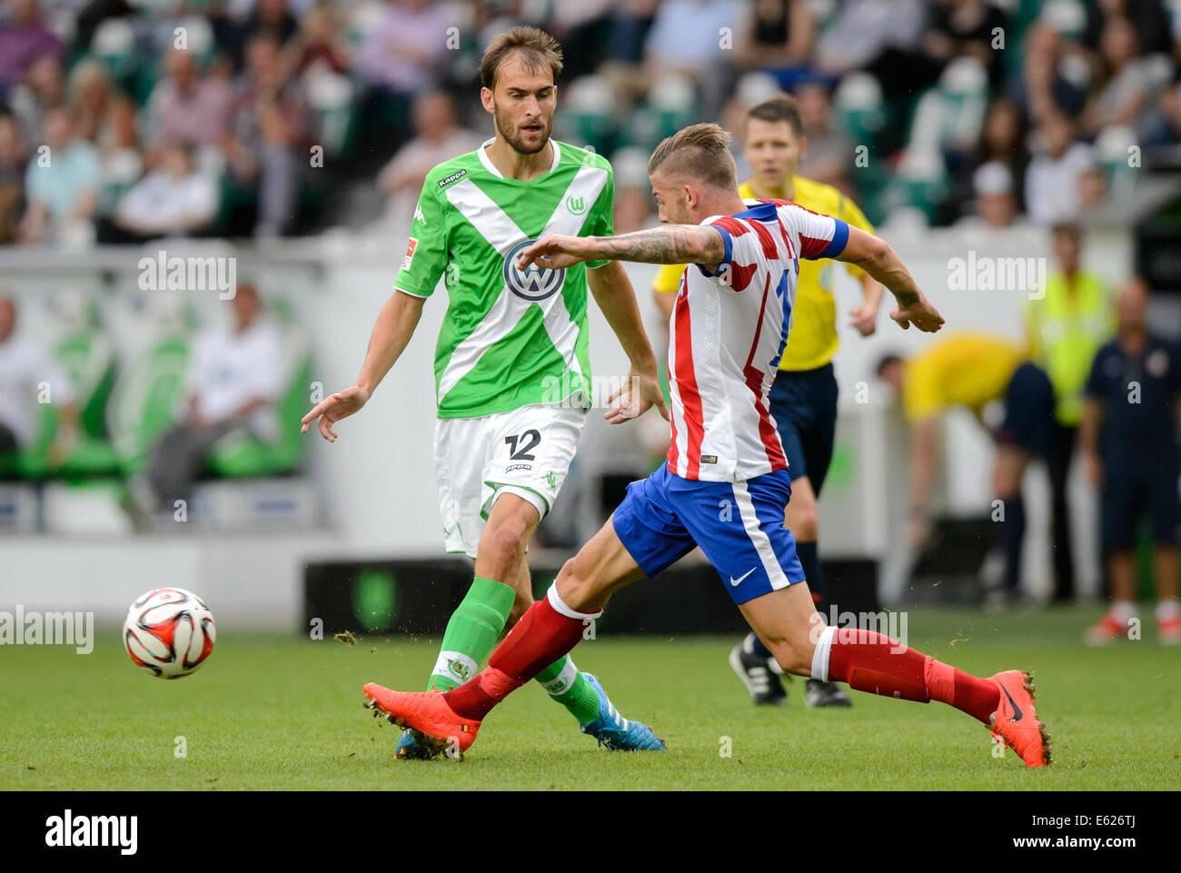 Wolfsburg, Germany. 10th Aug, 2014. Wolfsburg's Bas Dost (L) and Madris's Toby Alderweireld in action during the soccer test match between VfL Wolfsburg and Atletico Madrid at Volkswagen Arena in Wolfsburg, Germany, 10 August 2014. Photo: Thomas Eisenhuth/dpa/Alamy Live News Stock Photo