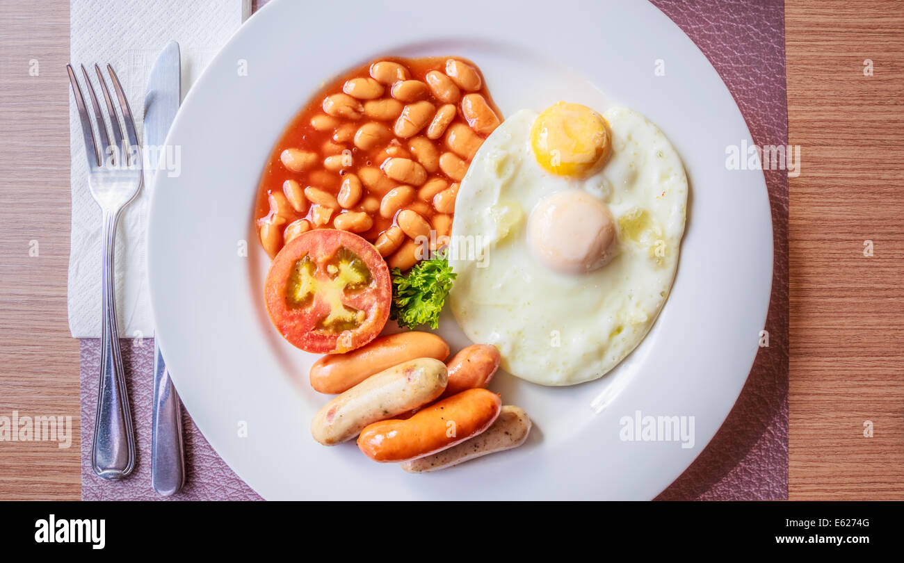 English breakfast with fried eggs, sausages, tomato, and beans Stock Photo