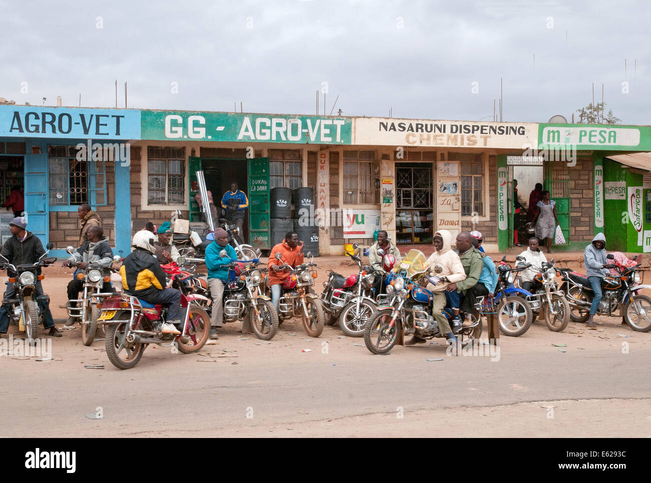 Motor cycle taxis outside corrugated iron shacks and roadside shops duka hotel at Kaijado on Namanga Nairobi road Kenya Africa Stock Photo