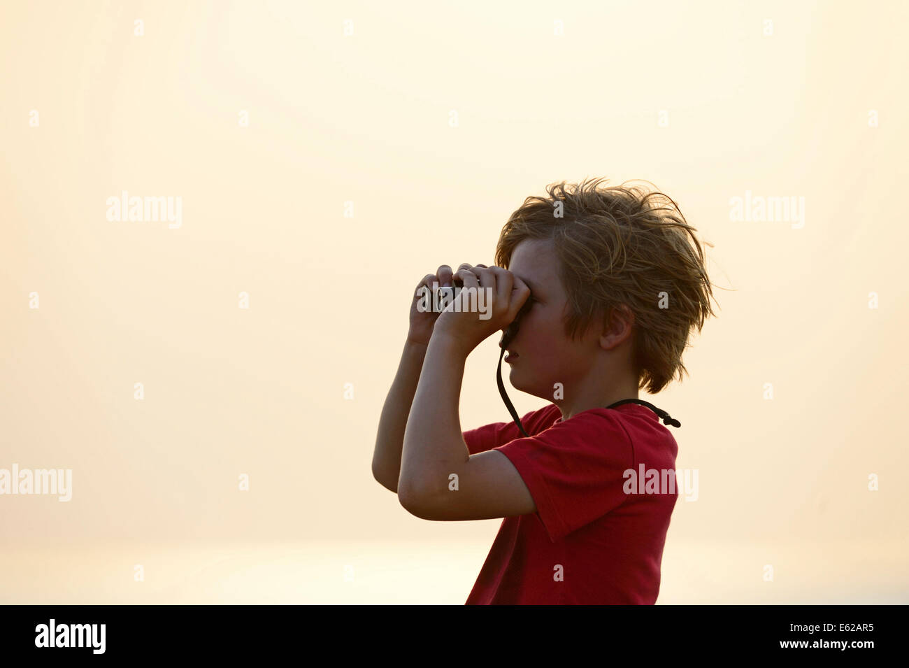 Young boy bird watching at Snettisham RSPB Reserve on the Wash Norfolk on a summer evening Stock Photo