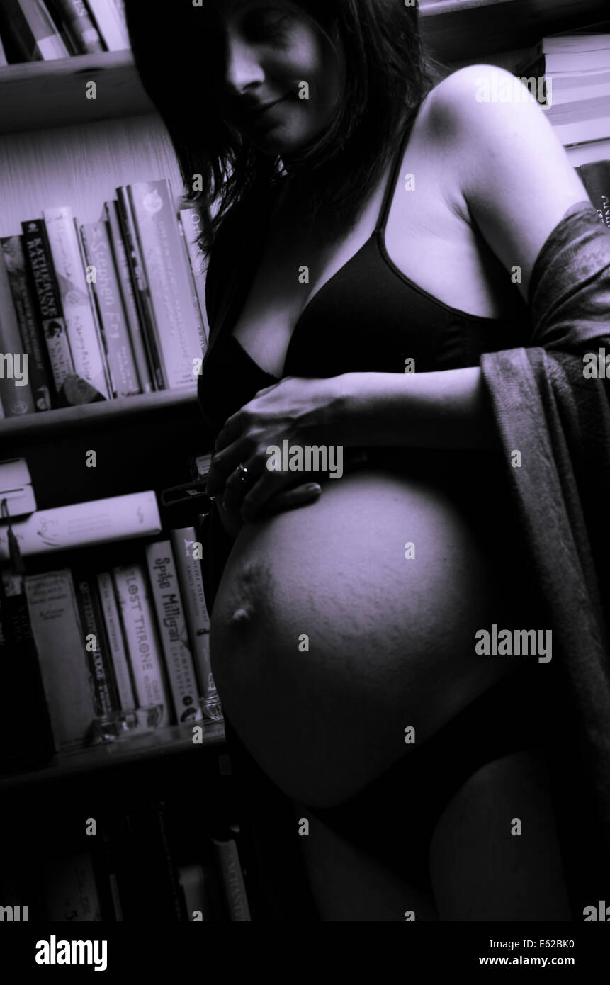 Pregnant woman with bump and bra - blue tone Stock Photo