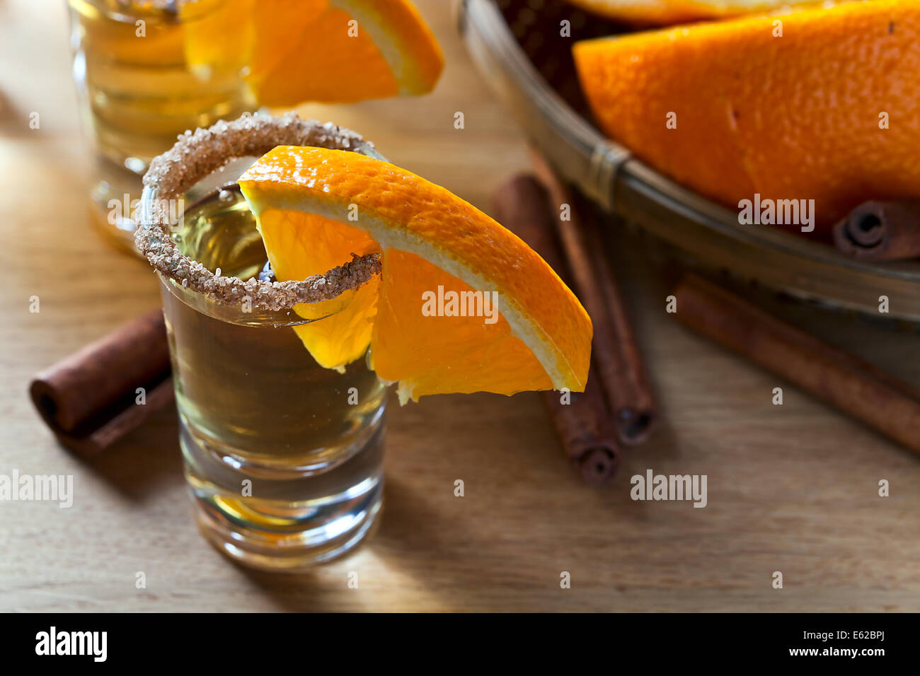 tequila with orange and cinnamon on a wooden table Stock Photo Alamy