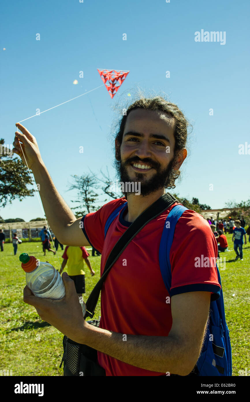 Smilling middle age man playing with a strange red kite Stock Photo