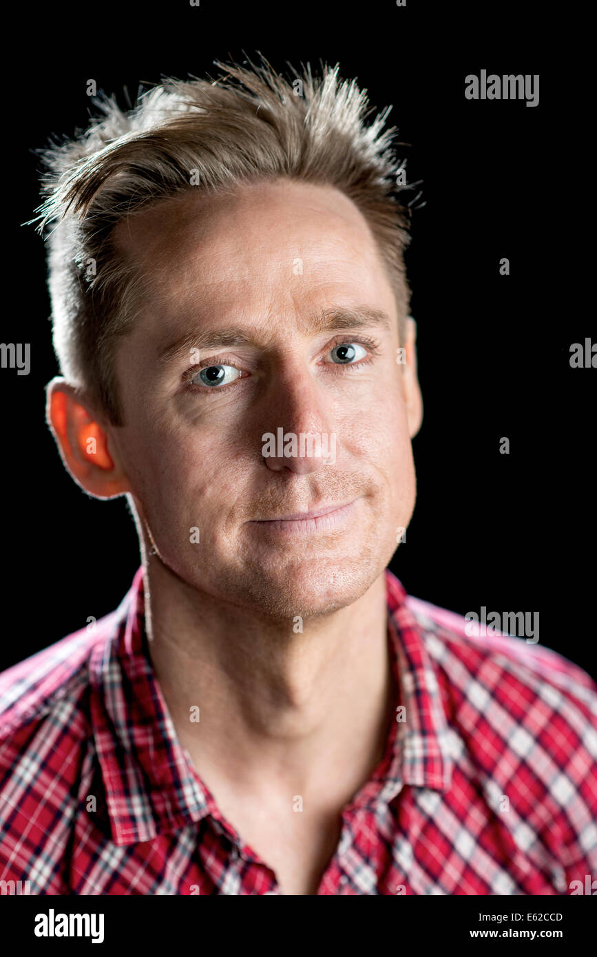 Headshots on black of a good looking man in his thirties with various facial expressions. Stock Photo