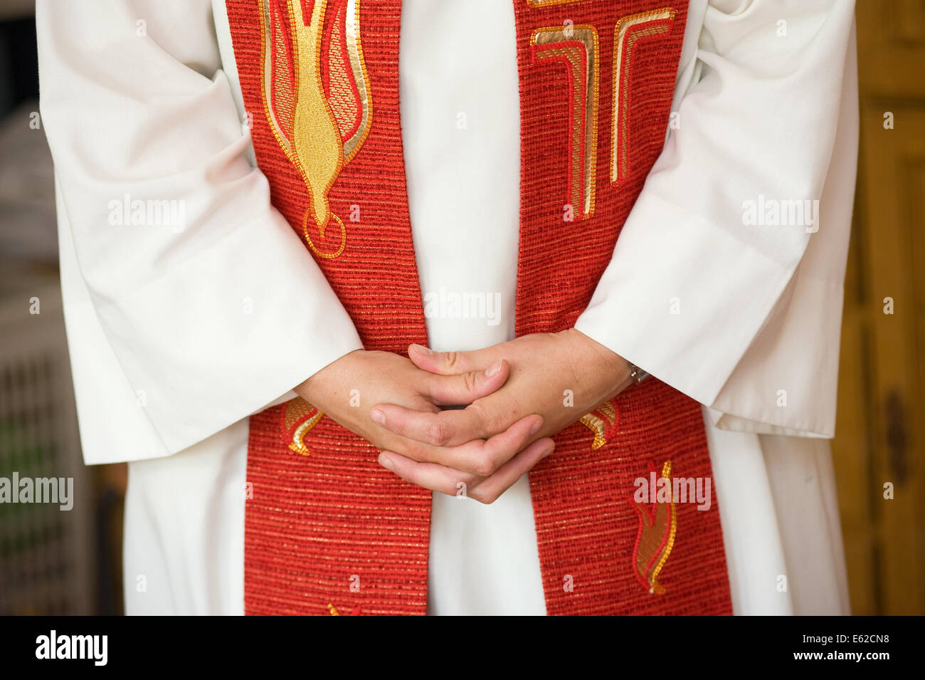 A female priest is folding her hands during praying Stock Photo
