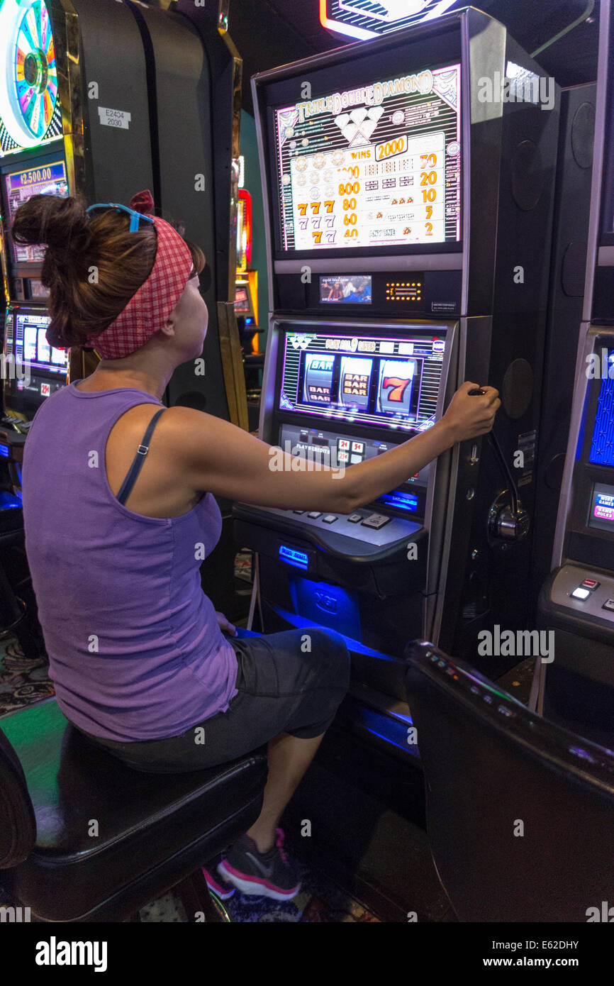 woman playing one armed bandit slot machine, casino, Wyndham and Melia hotels, The Bahamas Stock Photo