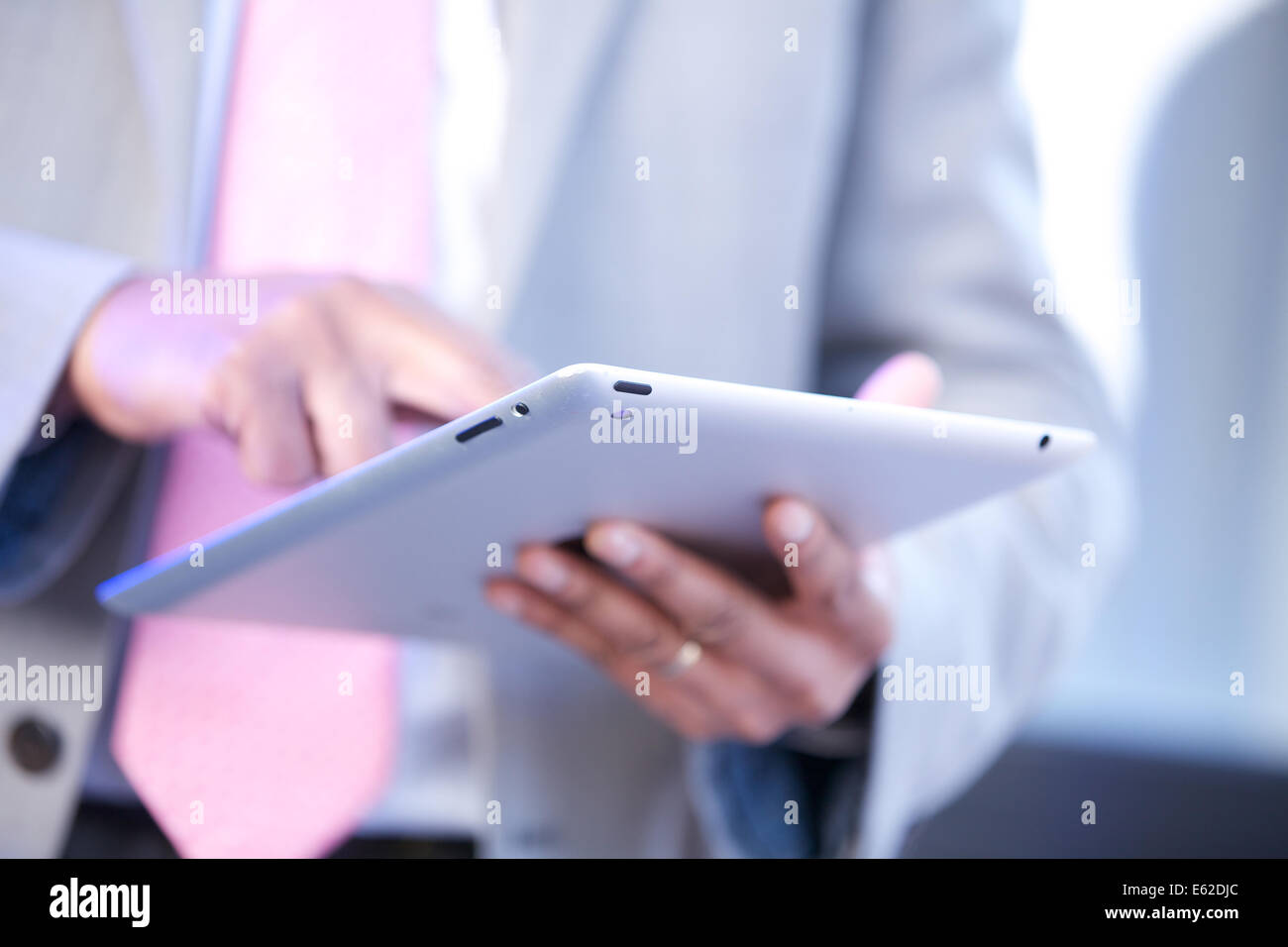 man in suit using iPad slate close up no face Stock Photo