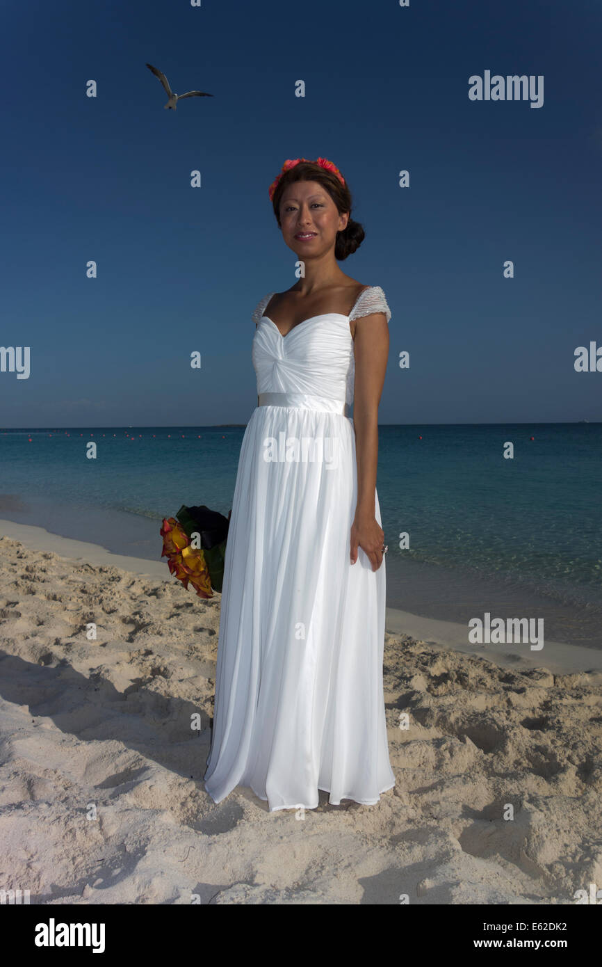 young girl in white bridal dress on Paradise Beach, Paradise Island, The Bahamas Stock Photo