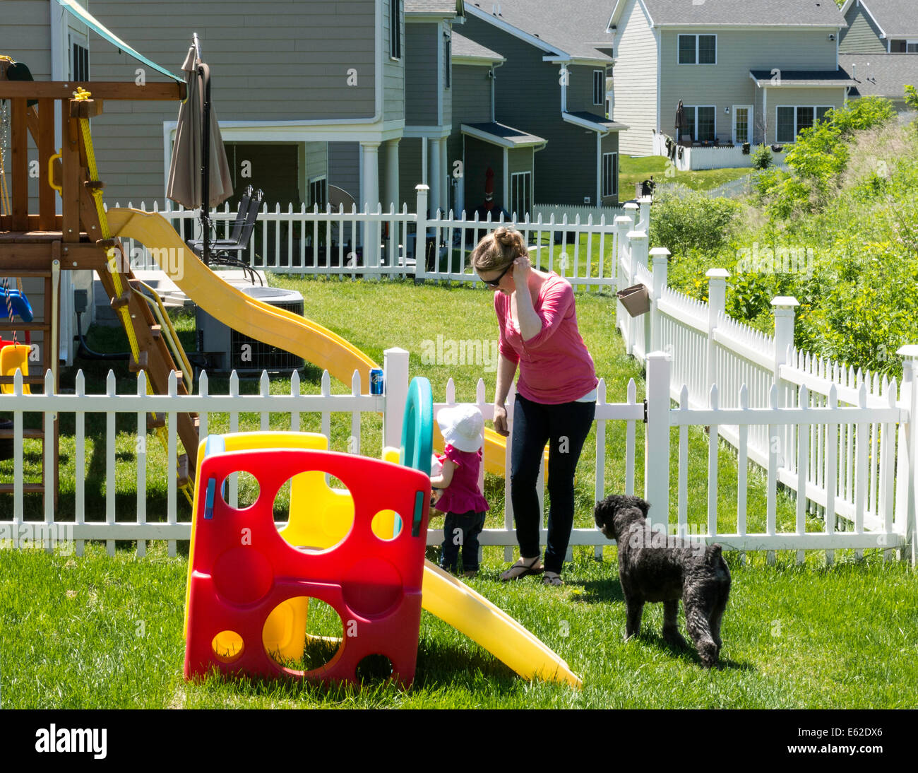 Mother Small Child And Dog Play In Backyard Of Army Officer Stock