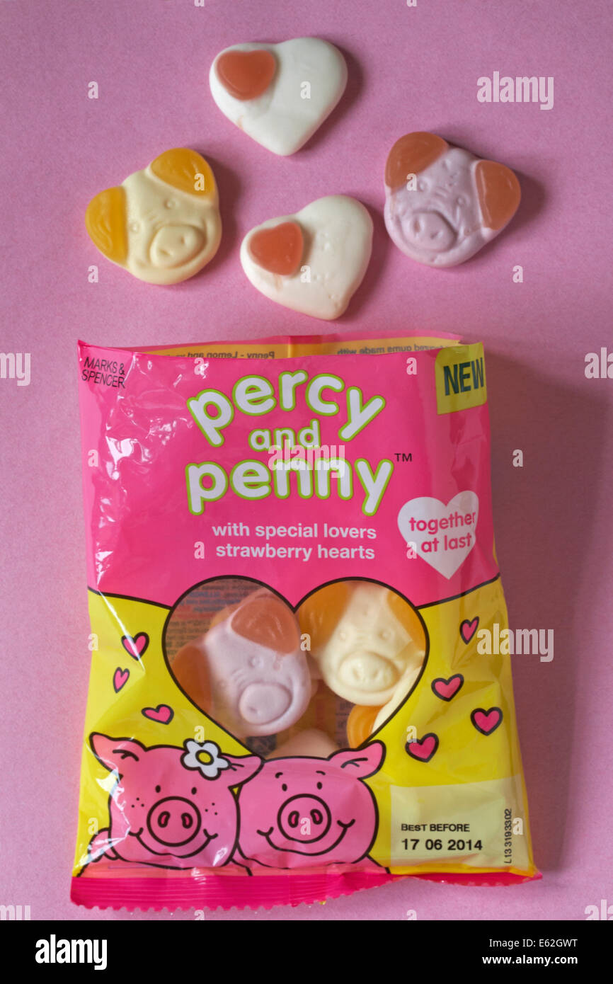 Bag of Marks & Spencer new percy and penny with special lovers strawberry hearts sweets together at last open with contents spilt isolated on pink Stock Photo