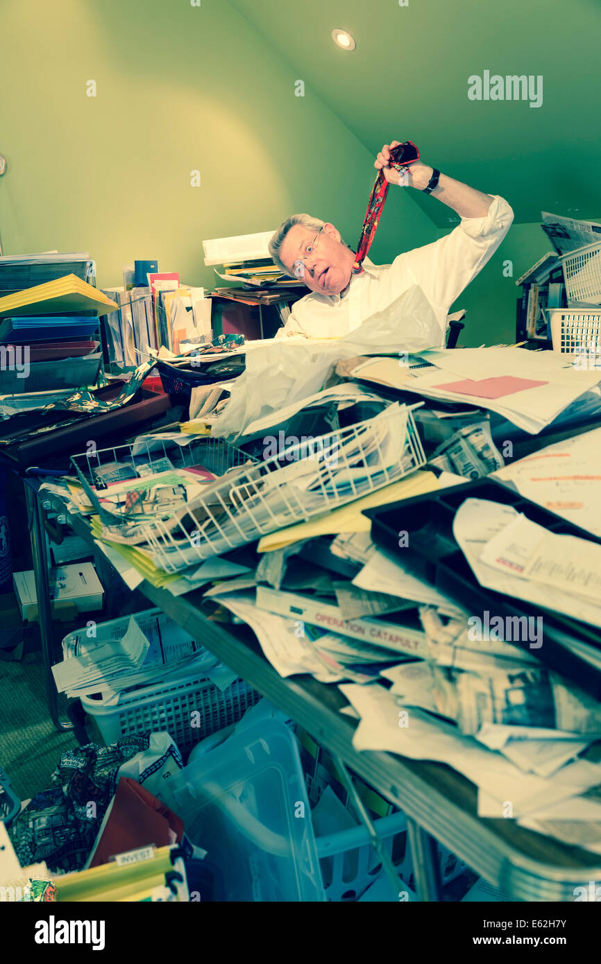 Businessman Hanging himself with tie in Hoarder's Messy Home Office, USA Stock Photo