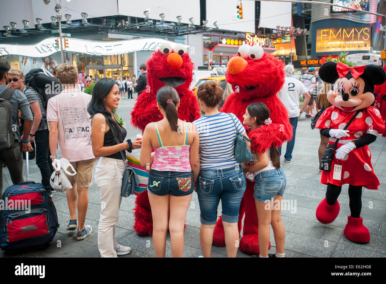 Twin Elmos solicit tips in Times Square in New York as Minnie Mouse trolls for tips. Stock Photo
